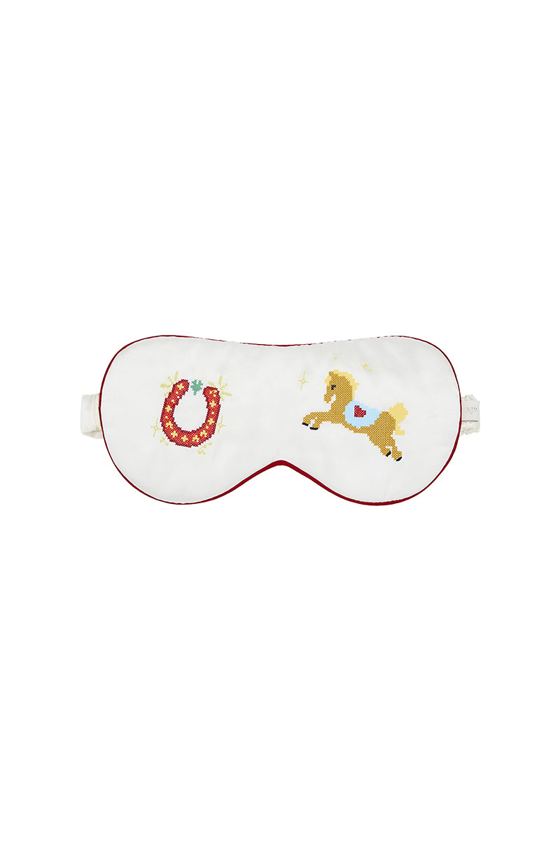 Pearl white embroidered eye mask in loungewear style with delicate stitching, designed for comfortable relaxation and sleep.
