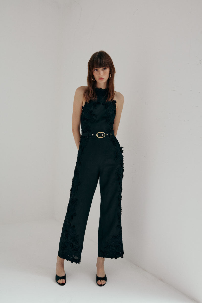 AISA Aurelia jumpsuit featuring a stylish design with a fitted waist and wide-leg pants, displayed on a hanger against a neutral background.