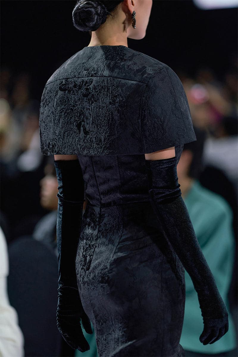 Black bustier gown with matching mini cape by I.H.F, featuring fitted bodice and elegant cape detail.
