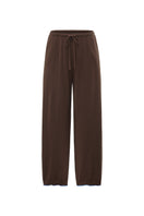 Unisex brown pants from Not Just Pajama featuring a relaxed fit and casual style, shown on a model.