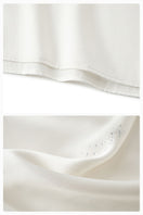 White feather gown with rhinestones from Not Just Pajama featuring luxurious feather details and elegant design.