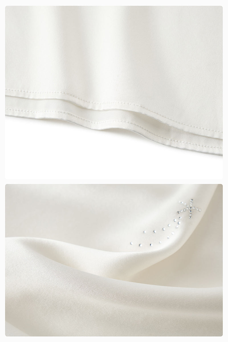White feather gown with rhinestones from Not Just Pajama featuring luxurious feather details and elegant design.