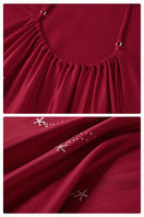 Bias-cut burgundy slip dress with rhinestones and feather embellishments, featuring a maxi length and delicate spaghetti straps.