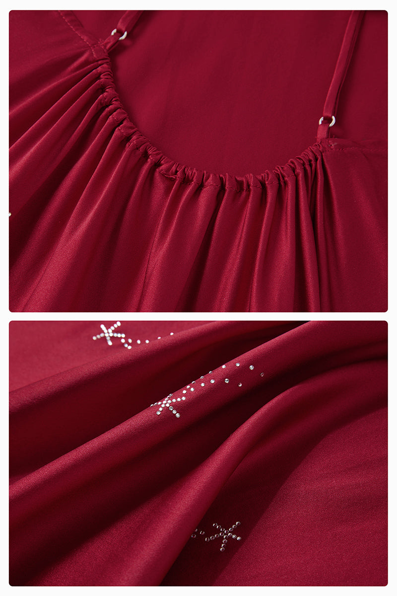 Bias-cut burgundy slip dress with rhinestones and feather embellishments, featuring a maxi length and delicate spaghetti straps.