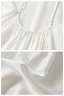 White bias-cut slip dress with rhinestones and feather details, featuring feather accents, by Not Just Pajama.