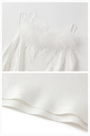 White bias-cut maxi dress with rhinestones and feather details from Not Just Pajama, featuring elegant feather embellishments.