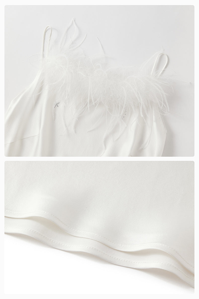 White bias-cut maxi dress with rhinestones and feather details from Not Just Pajama, featuring elegant feather embellishments.