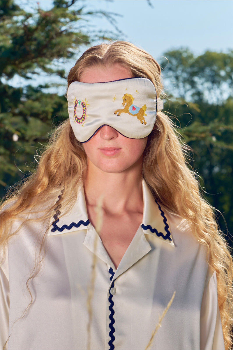 Pearl white embroidered eye mask from Not Just Pajama, a soft loungewear accessory for relaxing and restful sleep.