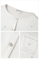White feather long-sleeve pajama set with rhinestones from Not Just Pajama featuring feather details and comfortable fabric.