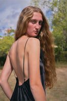 Black bias-cut slip dress with rhinestones and feather embellishments, featuring a flowy maxi dress design by Not Just Pajama.