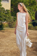 White bias-cut slip dress by Not Just Pajama featuring rhinestones and feather accents, with a flowing maxi dress silhouette.