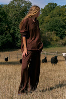 Unisex brown pants from Not Just Pajama, showing a relaxed fit with a comfortable waistband and casual style.