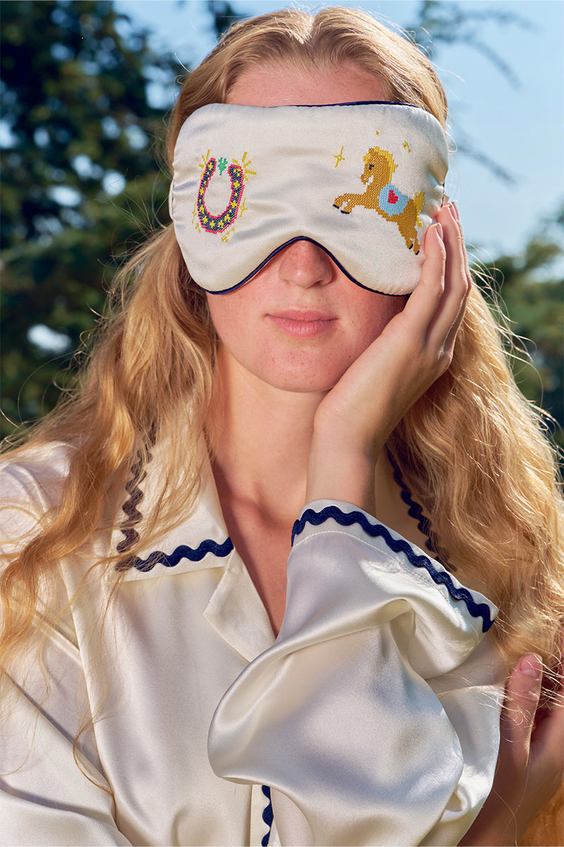 Pearl white embroidered eye mask from Not Just Pajama, soft loungewear accessory with delicate eye embroidery and comfortable fabric.