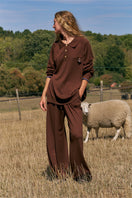 Unisex brown pants from Not Just Pajama featuring a comfortable fit and casual style, shown on a model.
