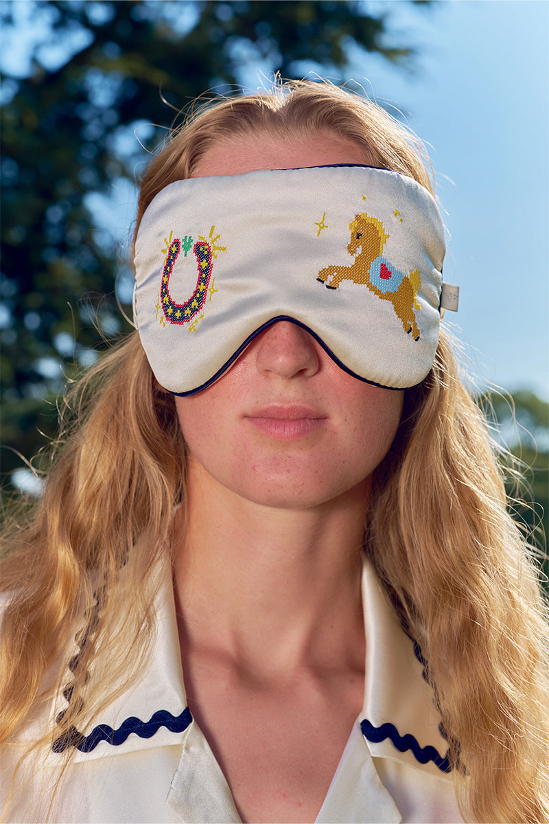 Pearl white embroidered eye mask from Not Just Pajama, soft loungewear accessory with delicate embroidery and comfortable fabric.