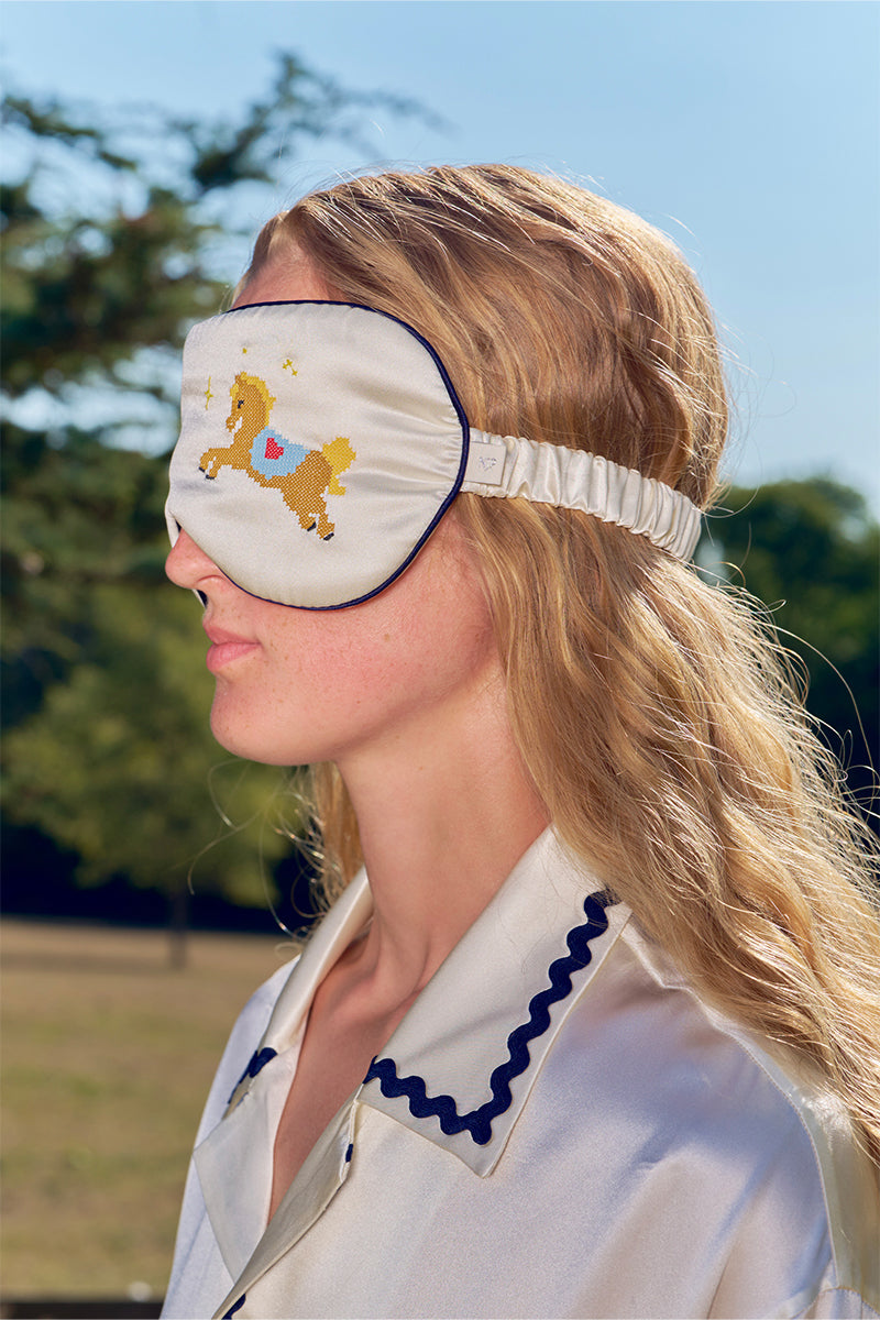 Pearl white embroidered eye mask from Not Just Pajama, luxurious loungewear accessory with soft fabric and delicate embroidery details.