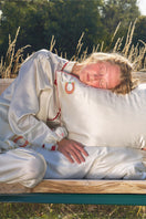 Pearl white loungewear pillowcase from Not Just Pajama, soft fabric with a smooth finish, shown on a bed.