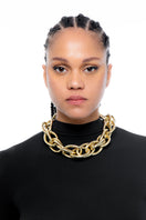 Gold chunky necklace by Silvia Gnecchi featuring large, bold links, styled as a statement jewelry piece.