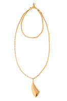 Gold VELA necklace by Silvia Gnecchi with a delicate chain and modern pendant, displayed on a neutral background.