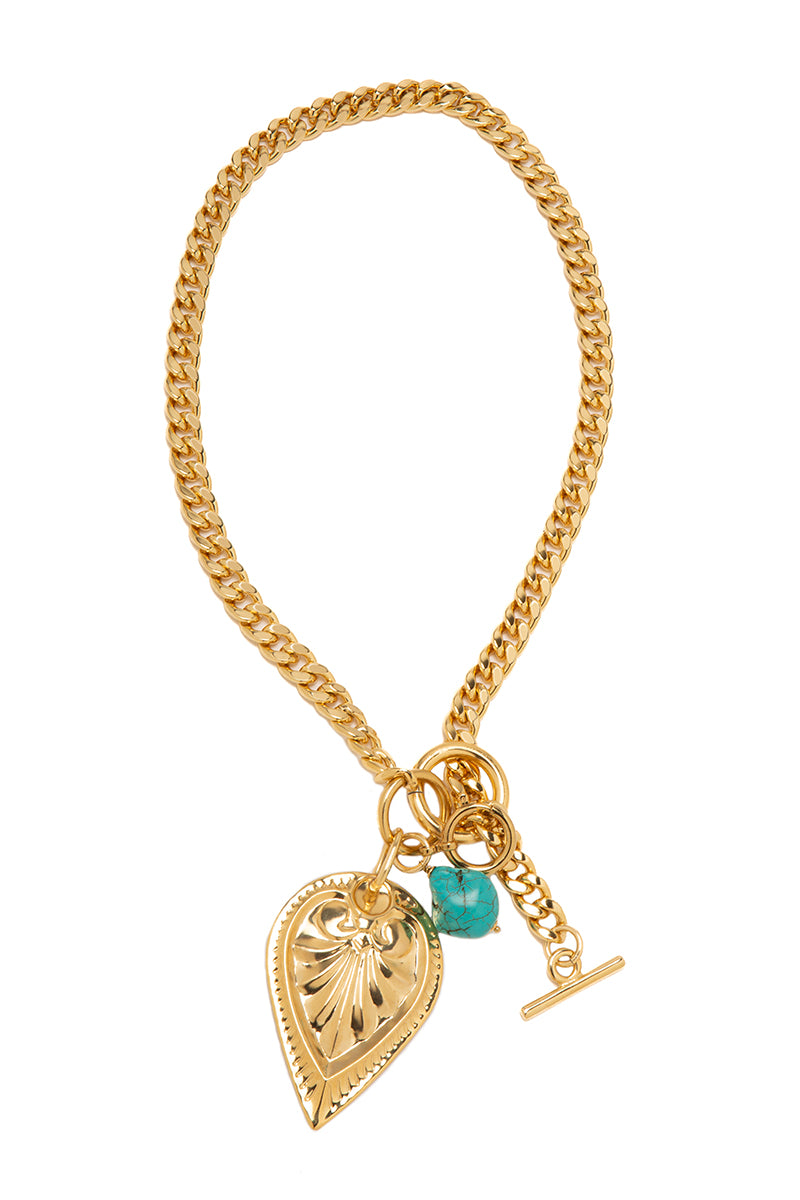 Gold Carrie necklace by Silvia Gnecchi featuring a delicate chain and minimalist pendant on a neutral background.