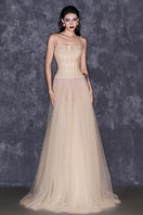 CEM nude sheer corset strap mesh floor-length gown styled as a maxi dress with elegant, flowing design and delicate mesh fabric.