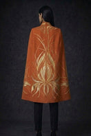Nadya Shah Cape Solaris in Solar Amber, stylish jacket with warm, vibrant solar amber color, displayed on a hanger.