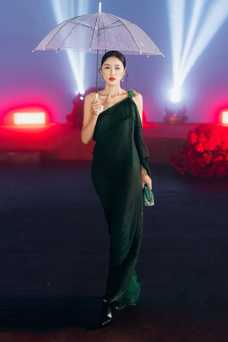 Green Valenciani fringed one-shoulder maxi gown with flowing fabric and elegant drape, perfect for formal occasions.