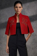 Nadya Shah Rouge Cape Eclat jacket displayed on a hanger, featuring vibrant red fabric and elegant design details.