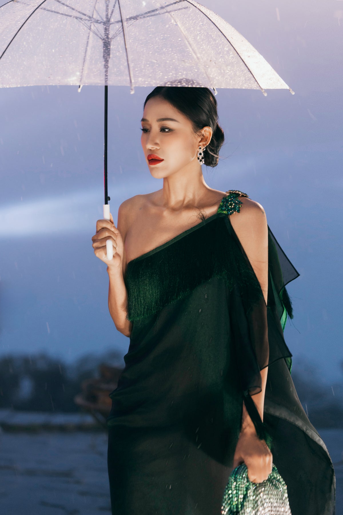 Green Valenciani fringed one-shoulder maxi gown with flowing fabric and elegant drape, perfect for formal occasions.