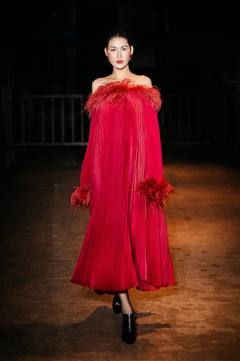 Red Valenciani midi dress with ostrich feather trim and pleated design, showcasing elegant fabric and sophisticated style.