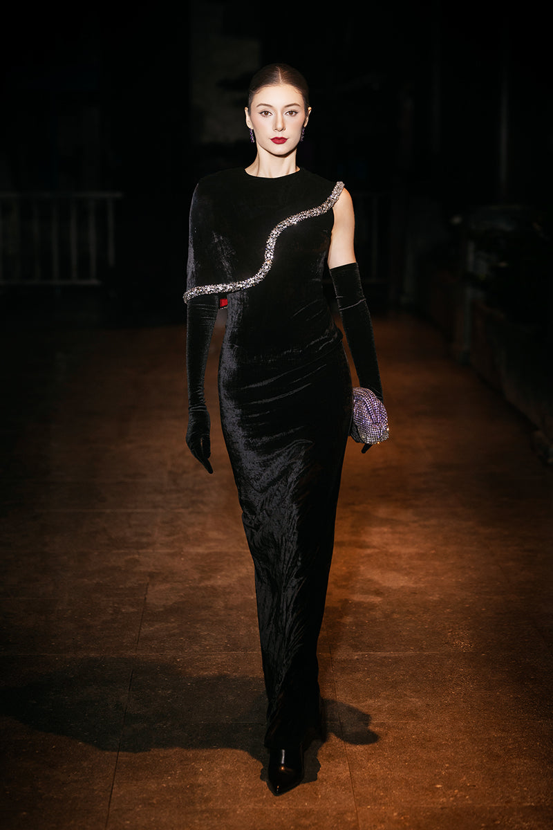 Valenciani black gown with gem-embellished trim cape, elegant evening dress with flowing fabric and intricate detailing.