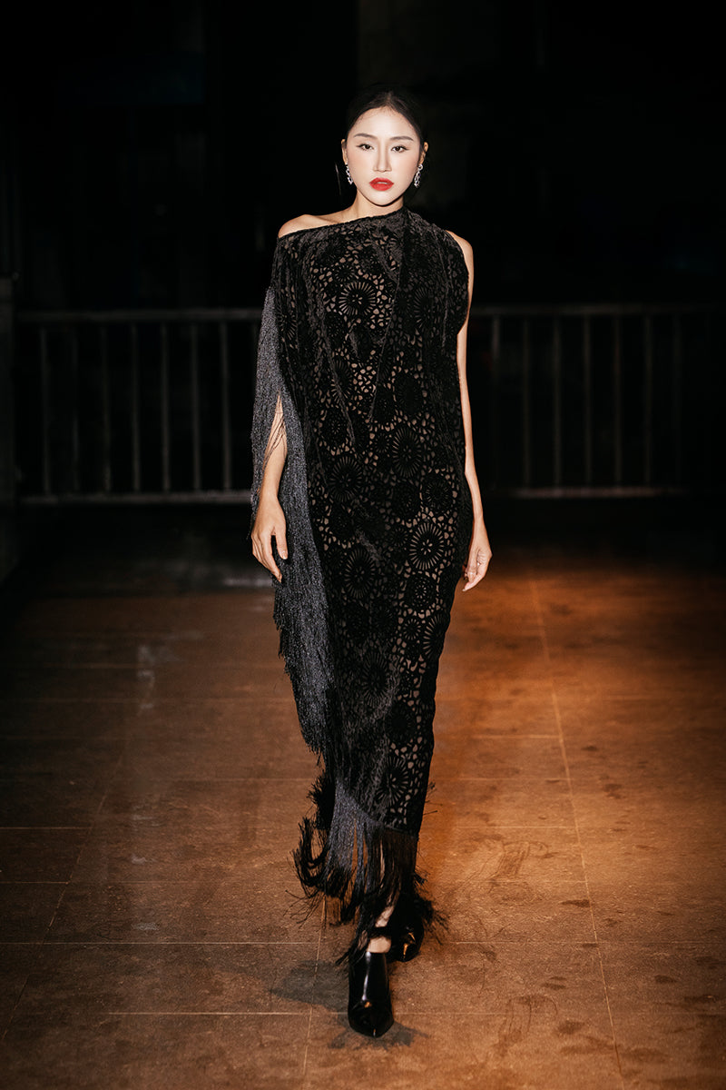 Black Valenciani draped gown with side fringe, elegant evening dress featuring flowing fabric and stylish design.