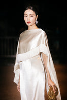 Cream Valenciani column gown with fringed cape, elegant floor-length dress with flowing silhouette and stylish fringe details.