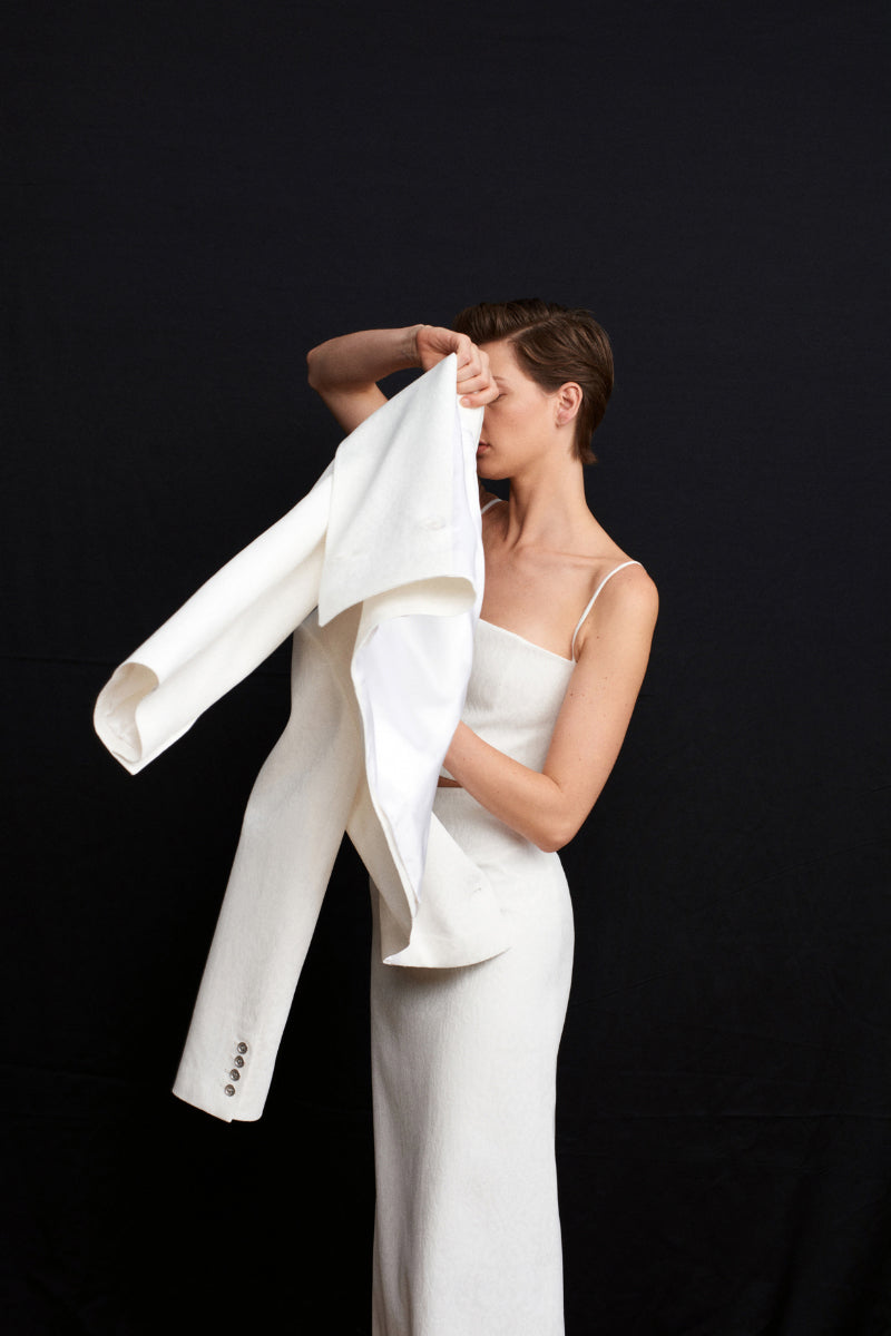 White Ancient Crop Blazer by Acaria Studio, stylish tailored jacket with modern design, displayed on a hanger.