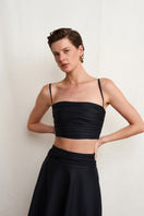 Black Wissy top by Acaria Studio, featuring a stylish and fitted design, shown on a model with a close-up view of the fabric and neckline.