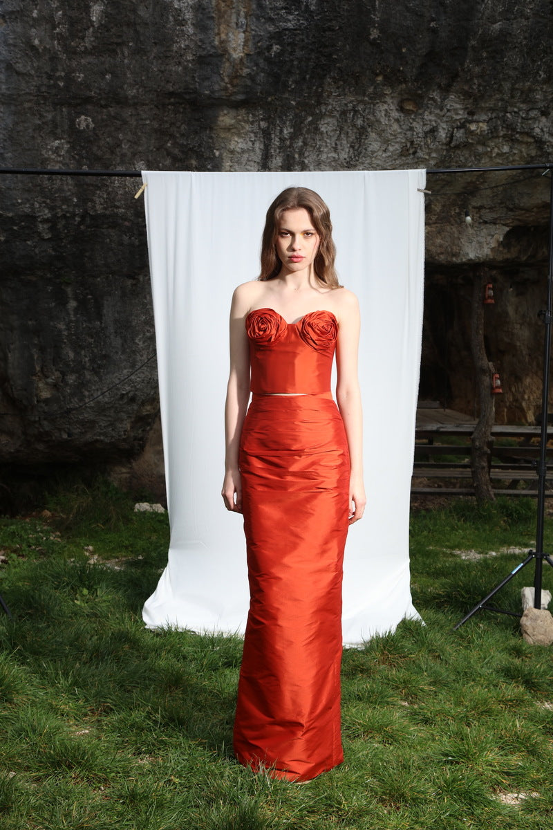 Aquarel Studio Neith Tangerine top shown on a hanger, featuring a vibrant orange color and lightweight fabric.