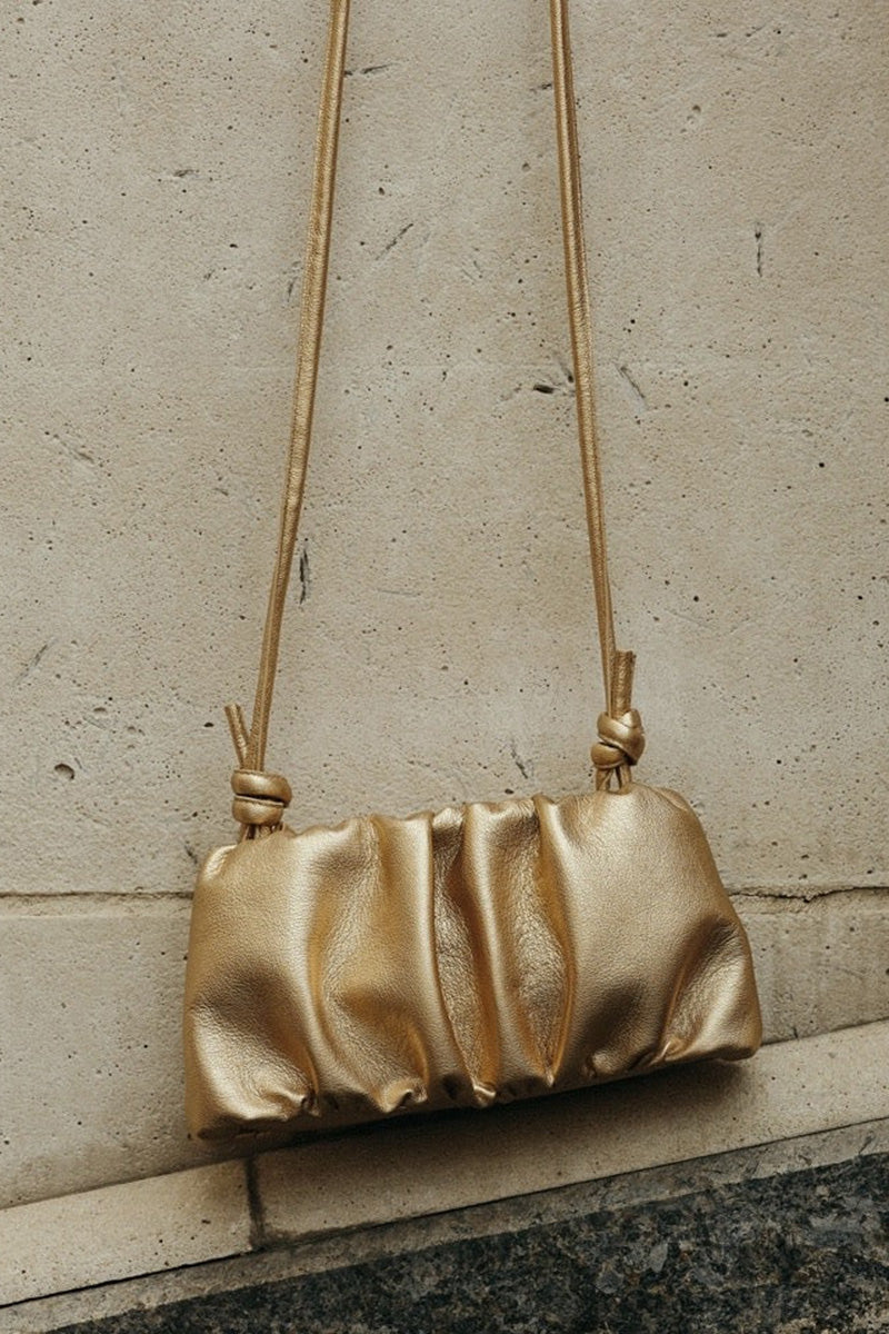 VIKELÉ STUDIO Rosie gold shoulder bag with sleek design and adjustable strap, featuring a metallic gold finish.