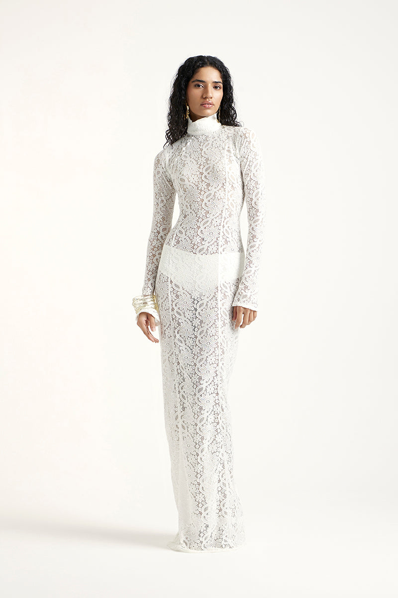 Off-white Deme By Gabriella amber maxi dress displayed on a model, featuring flowing fabric and elegant design.
