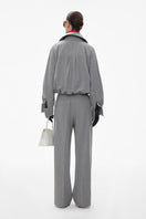 Gray straight-leg wool pinstripe trousers by ELENAREVA, shown on a model, featuring a tailored fit and classic pinstripe pattern.