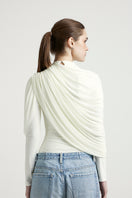 Deme By Gabriella Lisbeth off-white top, featuring a stylish design with a comfortable fit, displayed on a hanger.