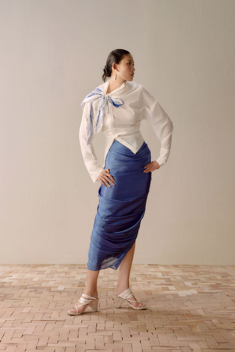 White asymmetric floral shirt by Levia featuring a unique design with floral patterns and a modern, stylish fit.