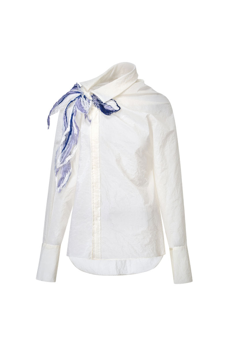 White asymmetric floral shirt by LECIA featuring a stylish, modern design with floral patterns and unique asymmetrical details.