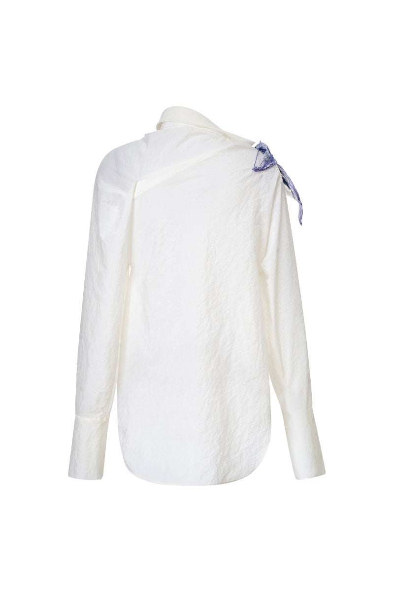 White asymmetric floral shirt by Levia featuring a stylish, modern design with floral patterns on lightweight fabric.
