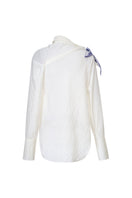 White asymmetric floral shirt by Levia featuring a stylish, modern design with floral patterns on lightweight fabric.