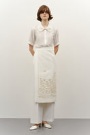 Deligan milk silk shirt with ornamental design, featuring a stylish and smooth fabric, displayed on a hanger.