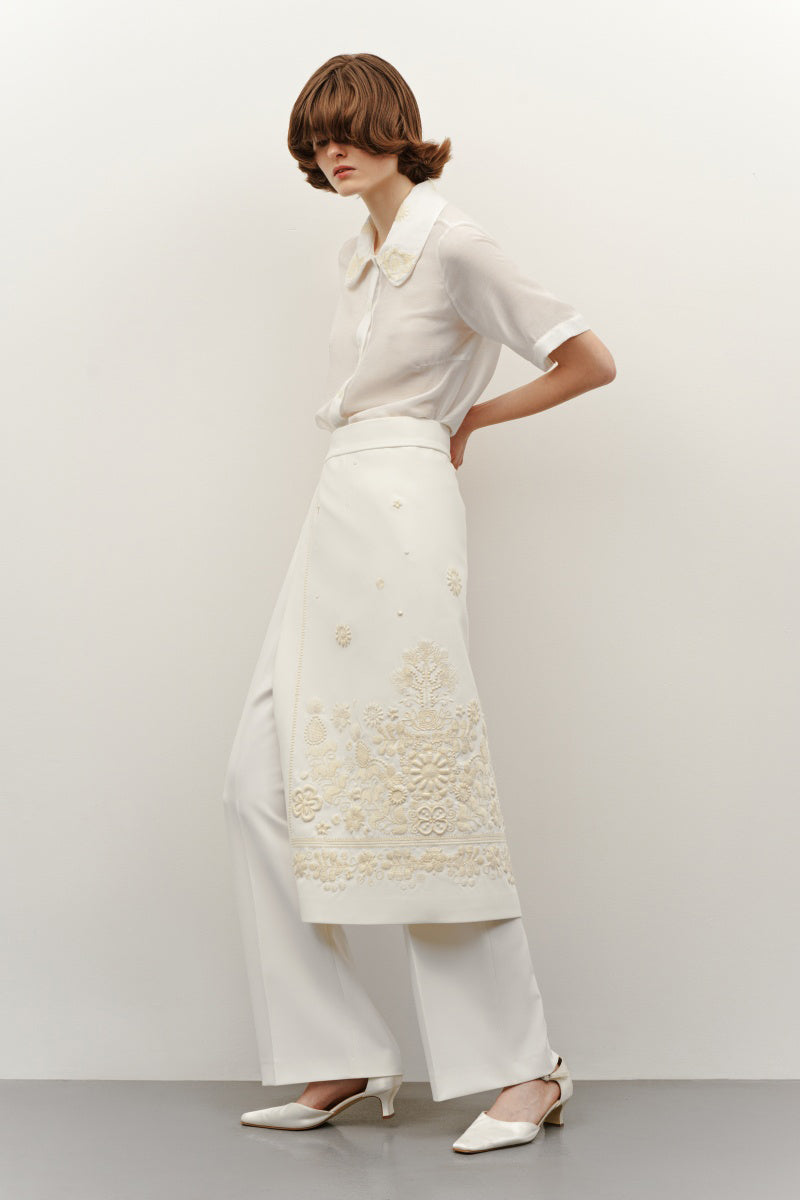 Cream-colored milk silk shirt with elegant ornament details from DELEGAN, featuring a classic collar and button-front design.