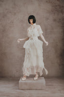 Elegant ivory Whisper Layer gown by White Plan featuring flowing layers and a sophisticated silhouette.