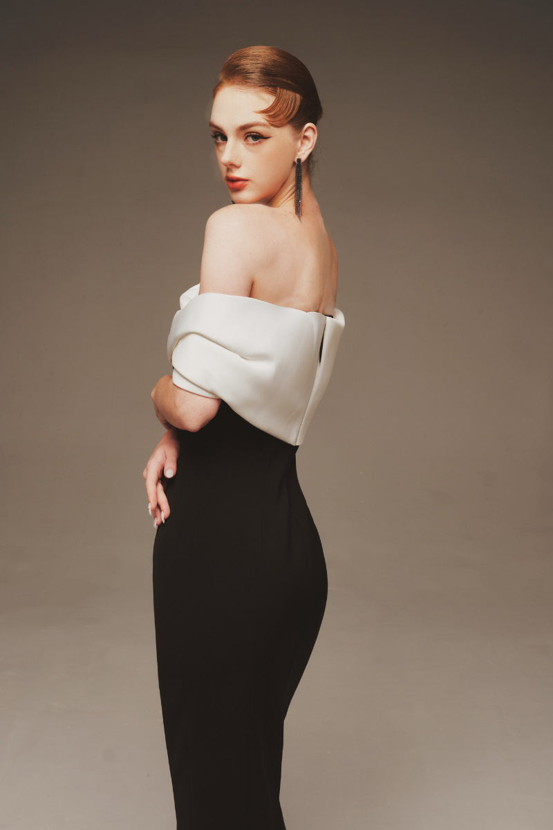Elegant Margée Atelier Serene off-shoulder maxi dress with flowing fabric and a stylish off-shoulder neckline.