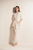 White tapered leg trousers by Valenciani, stylish pants with a modern fit, shown on a model in a casual setting.