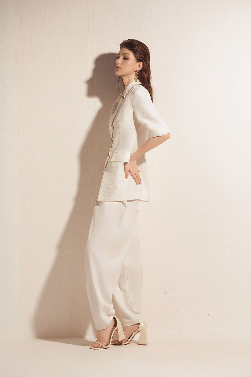 White tapered leg trousers by Valenciani, tailored pants with a sleek fit and clean design, shown on a model.